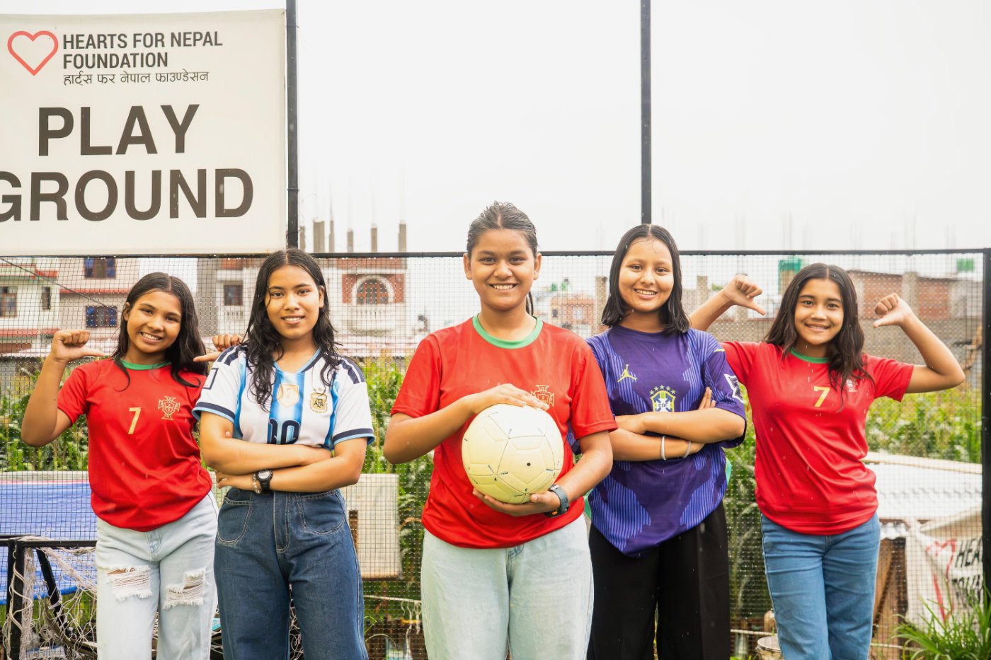 Five Hearts for Nepal girls in FIFA World Cup jerseys at the foundation playground