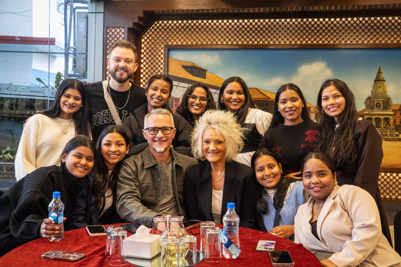 Pastor Dennis and the Hearts for Nepal team gathered around a table with the girls in Kathmandu