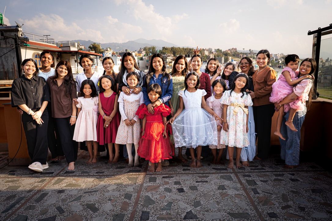 The girls and young women of the Hearts for Nepal home together on the rooftop, Kathmandu Valley behind them